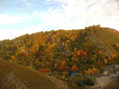 Golden autumn, blue sky and caucasus mountains