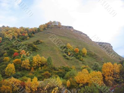 Golden autumn, blue sky and caucasus mountains