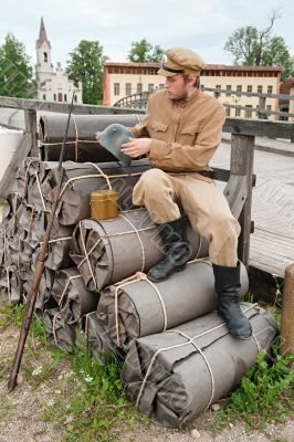 Retro style picture with soldier on bundles