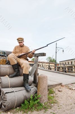 Retro style picture with soldier on the bundles