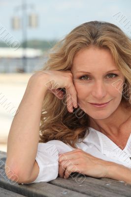 Blond woman sat on bench