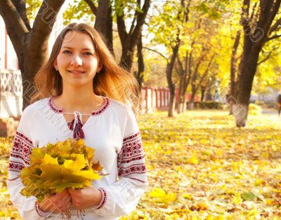 Young lady sitting in a park at fall time