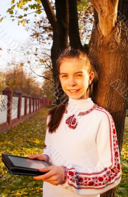 Teen girl with e-book reader in a park