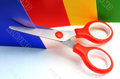 Colorful paper with child`s scissors