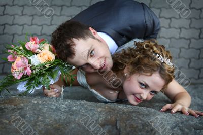 Bride and groom near a wall