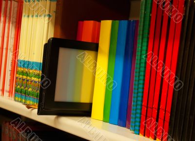 Row of colorful books and electronic book reader