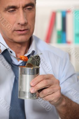 Man eating from tin can