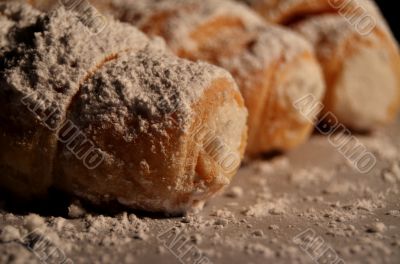 Cream filled pastries covered in powdered sugar.