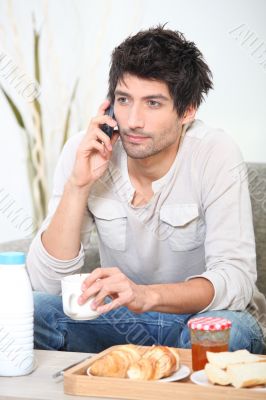 Man making a phone call over breakfast
