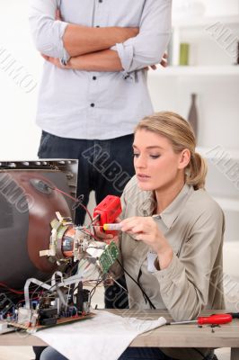 Woman repairing television