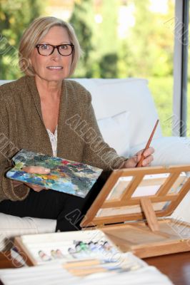 senior woman painting at home