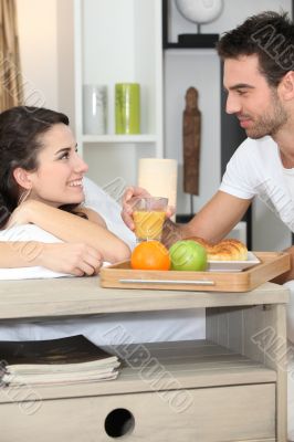 Couple enjoying romantic meal in bedroom