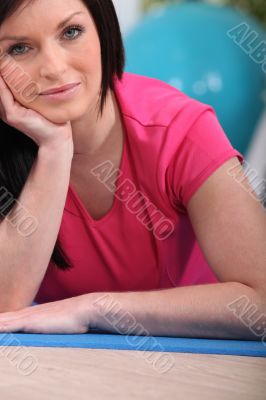Woman sitting on a mat in a gym