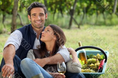 couple picking grapes and drinking wine