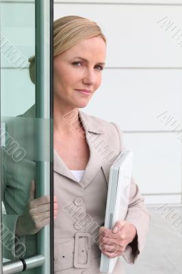 Blonde woman with a laptop in her arms