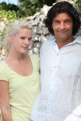 A couple standing in front of a stone wall