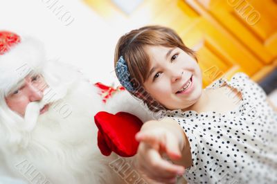 Christmas theme: Santa Claus and little girl having a fun. 