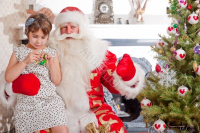 Christmas theme: Santa Claus and little girl having a fun. 