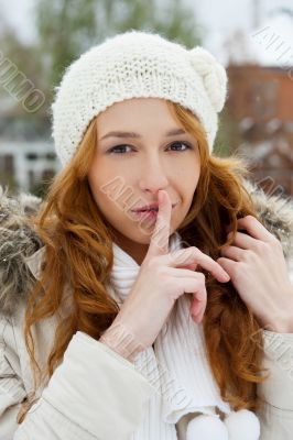 Portrait of young pretty woman in winter park.