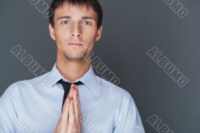 Profile shot of professional man holding hands up to face