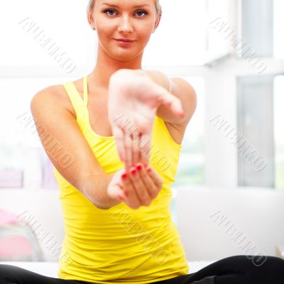 Portrait of beautiful young woman doing exercise at her home