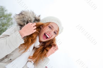 Young pretty woman enjoying herself at winter park. Laughing and