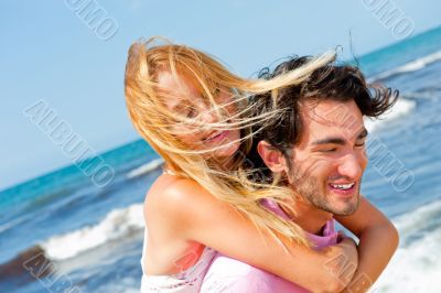 An attractive couple fooling around on the beach