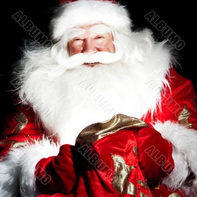 Santa sitting at the Christmas room and looking into the sack