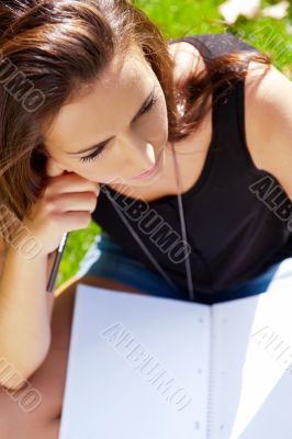 A shot of an caucasian student studying on campus lawn