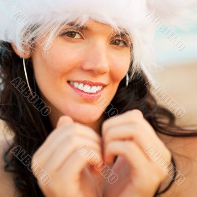 Young beautiful woman wearing christmas hat showing heart shape 