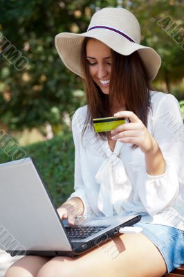 Young elegant woman wearing straw hat and white dress holding cr