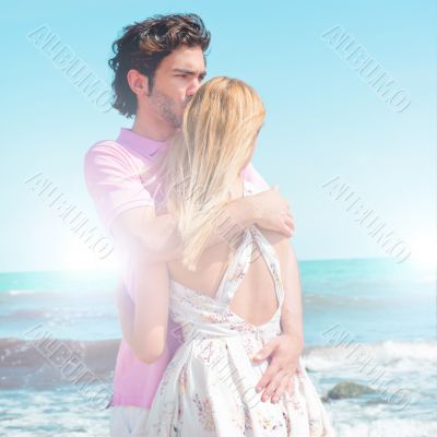 Portrait of young couple in love embracing at beach and enjoying