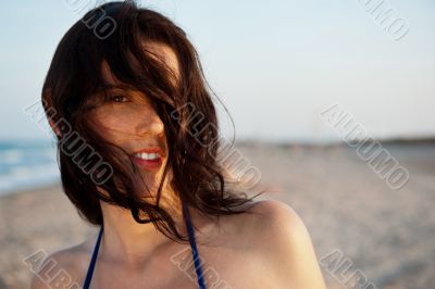 Beautiful attractive young woman at the beach standing, admiring