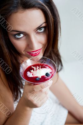 Portrait of an young beautiful woman eating an ice cream in cafe