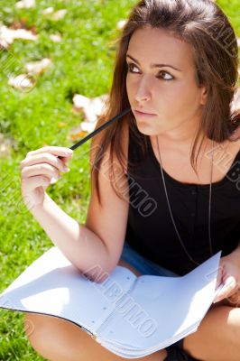 A shot of an caucasian student studying on campus lawn