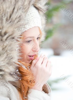 Portrait of pretty girl at winter background wearing warm clothe