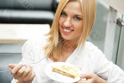 Portrait of young pretty smiling woman eating cake at shopping m