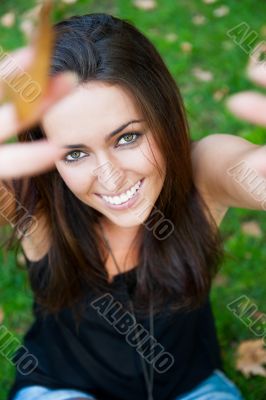 Portrait of smiling young girl sitting on grass in the forest an