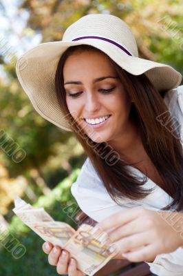 Portrait of young pretty woman sitting on bench at summer or aut