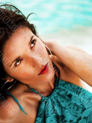 Pretty young woman with hot look and sexy smile sitting on beach