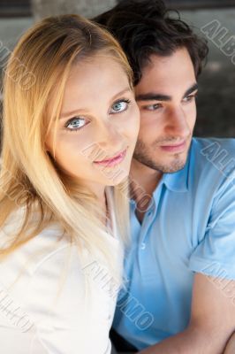 Portrait of love couple embracing outdoor in park looking happy