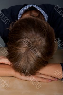 Portrait of tired man laying face down on table at his office