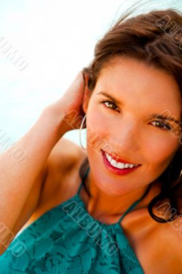 Pretty young woman with hot look and sexy smile sitting on beach