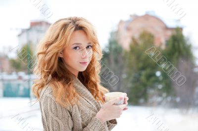 Portrait of young pretty red hair woman with cup of hot coffee o