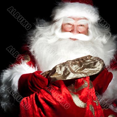 Santa sitting at the Christmas room and looking into the sack