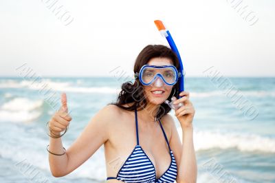 Young hispanic woman with wet skin and with a snorkel standing o
