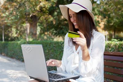 Young elegant woman wearing straw hat and white dress holding cr