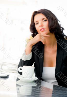 Portrait of pretty young business woman sitting relaxed at outdo