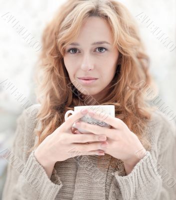 Portrait of beautiful red hair girl drinking coffee on winter ba