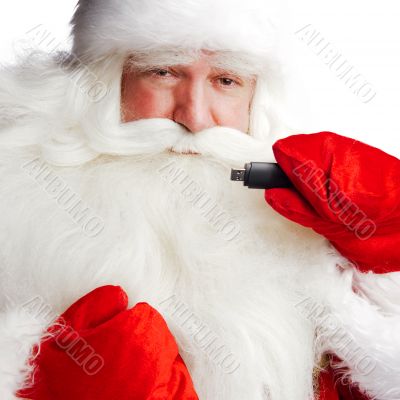 Traditional Santa Claus holding 3g usb modem in his arm on foreg